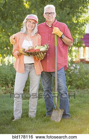 Stock Photograph - Caucasian couple gardening in backyard. Fotosearch