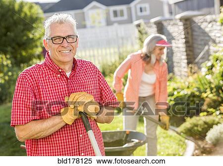 Stock Photography - Caucasian couple gardening in backyard. Fotosearch