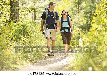 Stock Photography - Caucasian couple hiking on path. Fotosearch