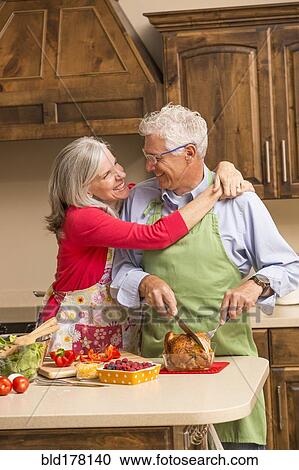 Caucasian couple hugging in kitchen View Large Photo Image Stock Image - Caucasian couple hugging in kitchen. Fotosearch