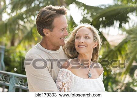 Stock Image - Caucasian couple hugging outdoors. Fotosearch