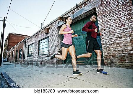 Caucasian couple jogging on sidewalk View Large Photo Image Stock Photo - Caucasian couple jogging on sidewalk. Fotosearch