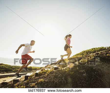 Stock Photo - Caucasian couple jogging uphill. Fotosearch