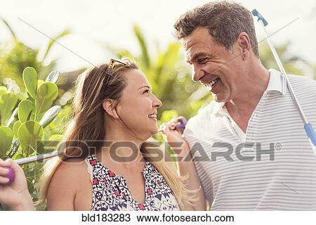 Stock Image - Caucasian couple playing miniature golf. Fotosearch