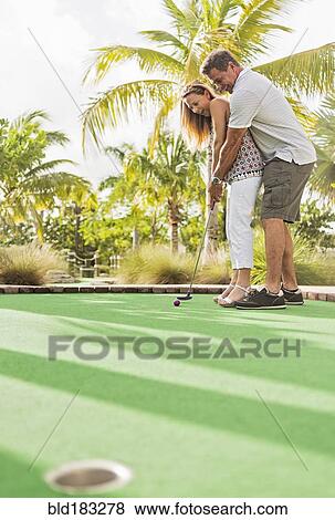Stock Photo - Caucasian couple playing miniature golf. Fotosearch