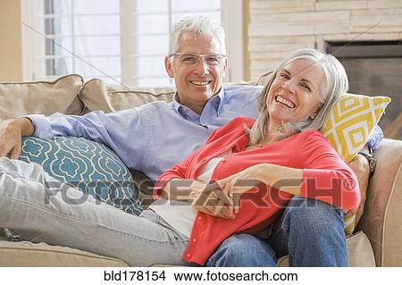 Picture - Caucasian couple relaxing on sofa. Fotosearch