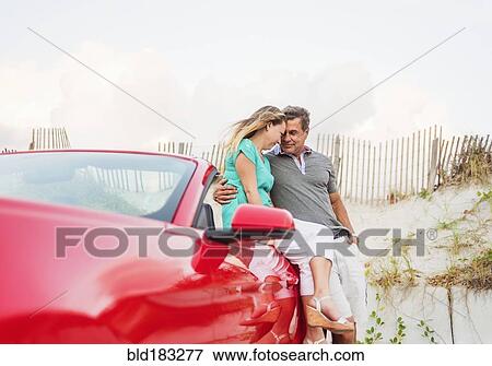 Caucasian couple sitting on convertible View Large Photo Image Stock Photo - Caucasian couple sitting on convertible. Fotosearch