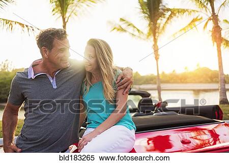 Stock Photography - Caucasian couple sitting on convertible. Fotosearch
