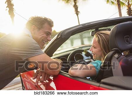 Caucasian couple talking in convertible View Large Photo Image Stock Photograph - Caucasian couple talking in convertible. Fotosearch