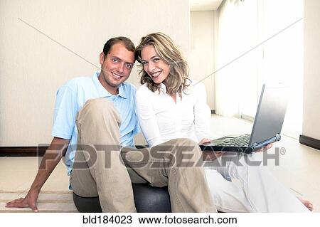 Caucasian couple using laptop on ball on floor View Large Photo Image Stock Image - Caucasian couple using laptop on ball on floor. Fotosearch