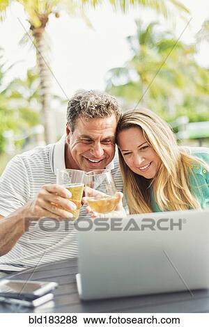 Caucasian couple video chatting on laptop outdoors View Large Photo Image Stock Photo - Caucasian couple video chatting on laptop outdoors. Fotosearch