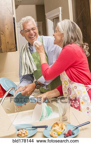Caucasian couple washing dishes in kitchen View Large Photo Image Picture - Caucasian couple washing dishes in kitchen. Fotosearch