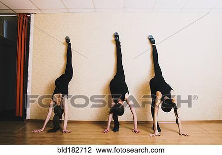 Stock Image - Caucasian dancers stretching in studio. Fotosearch