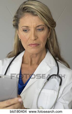 Picture - Caucasian doctor using cell phone. Fotosearch
