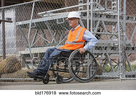 Stock Photo - Caucasian engineer in wheelchair on construction site. Fotosearch