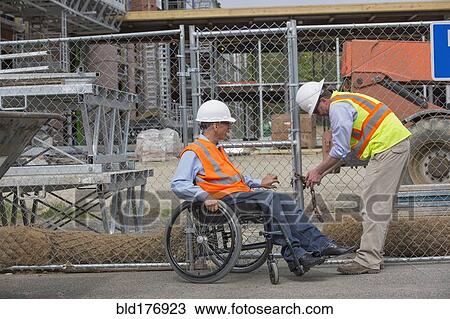 Stock Image - Caucasian engineers working on construction site. Fotosearch