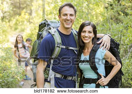 Stock Image - Caucasian family hiking on path. Fotosearch