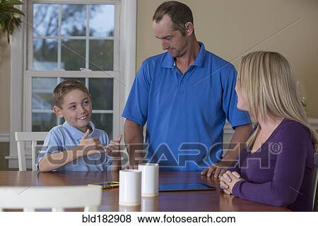 Caucasian family signing at dinner table View Large Photo Image Stock Photo - Caucasian family signing at dinner table. Fotosearch