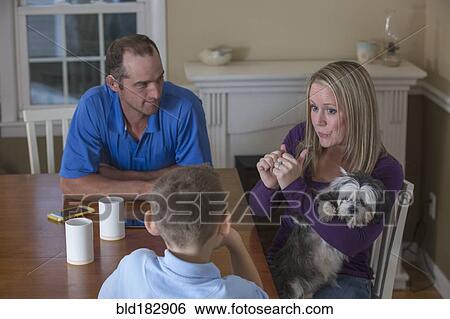 Caucasian family signing at dinner table View Large Photo Image Stock Photograph - Caucasian family signing at dinner table. Fotosearch