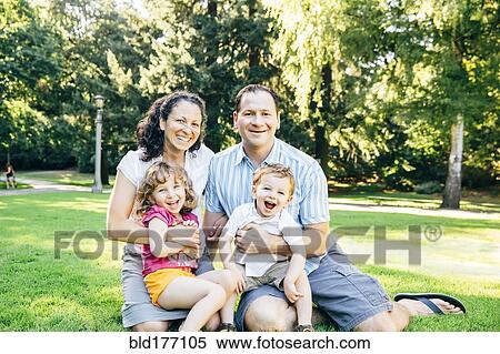Stock Photography - Caucasian family sitting in park. Fotosearch