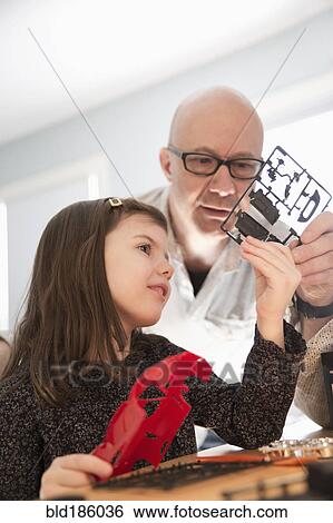 Stock Photograph - Caucasian father and daughter building model toy. Fotosearch
