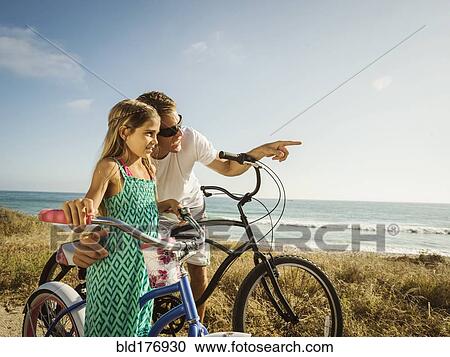 Caucasian father and daughter riding bicycles on beach View Large Photo Image Stock Image - Caucasian father and daughter riding bicycles on beach. Fotosearch