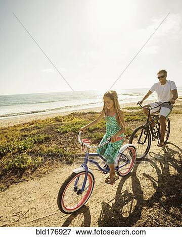 Caucasian father and daughter riding bicycles on beach View Large Photo Image Stock Photo - Caucasian father and daughter riding bicycles on beach. Fotosearch