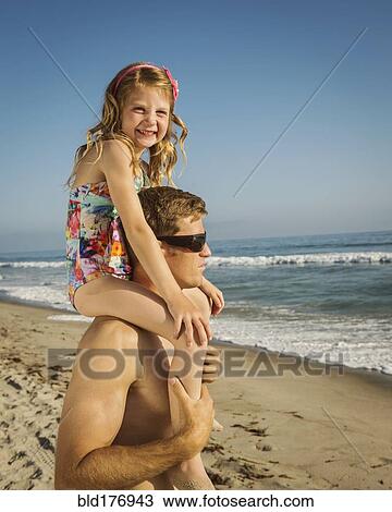 Caucasian father carrying daughter on beach View Large Photo Image Stock Image - Caucasian father carrying daughter on beach. Fotosearch