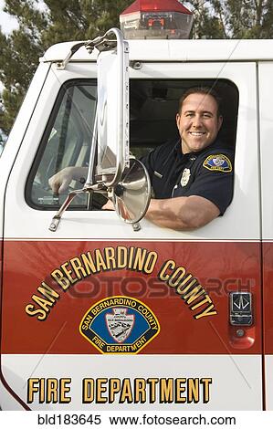 Caucasian firefighter smiling in fire truck View Large Photo Image Stock Photography - Caucasian firefighter smiling in fire truck. Fotosearch