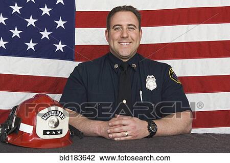 Caucasian firefighter smiling near American flag View Large Photo Image Stock Image - Caucasian firefighter smiling near American flag. Fotosearch