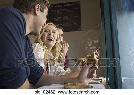 Caucasian friends eating pizza in cafe View Large Photo Image Stock Image - Caucasian friends eating pizza in cafe. Fotosearch
