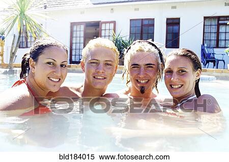 Stock Photography - Caucasian friends smiling in swimming pool. Fotosearch