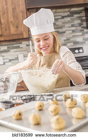 Stock Photo - Caucasian girl baking in kitchen. Fotosearch