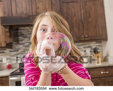 Caucasian girl blowing soap bubble View Large Photo Image Picture - Caucasian girl blowing soap bubble. Fotosearch