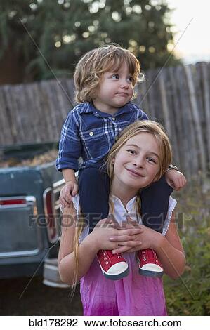 Caucasian girl carrying brother on shoulders View Large Photo Image Stock Image - Caucasian girl carrying brother on shoulders. Fotosearch