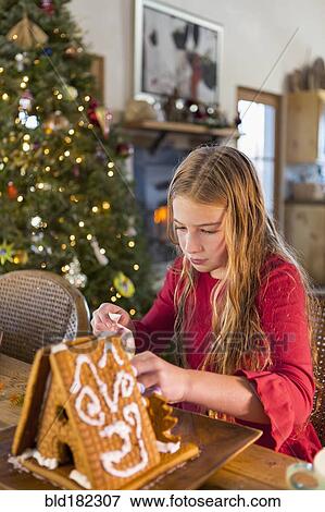 Caucasian girl decorating gingerbread house View Large Photo Image Stock Photo - Caucasian girl decorating gingerbread house. Fotosearch