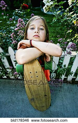 Caucasian girl holding skateboard on sidewalk View Large Photo Image Stock Photograph - Caucasian girl holding skateboard on sidewalk. Fotosearch