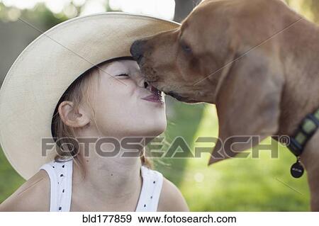 Stock Photo - Caucasian girl kissing dog outdoors. Fotosearch