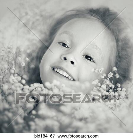 Stock Photo - Caucasian girl laying in flowers. Fotosearch