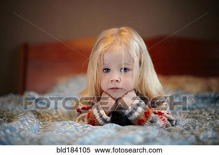 Stock Photography - Caucasian girl laying on bed. Fotosearch