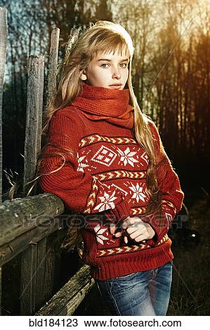 Stock Image - Caucasian girl leaning on fence. Fotosearch