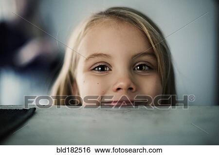 Stock Photograph - Caucasian girl peering over counter. Fotosearch