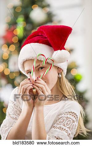 Caucasian girl peering through Christmas candy canes View Large Photo Image Stock Image - Caucasian girl peering through Christmas candy canes. Fotosearch