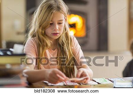 Stock Photo - Caucasian girl playing cards. Fotosearch