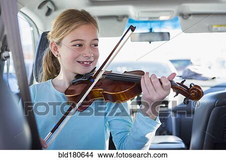 Caucasian girl playing violin in car View Large Photo Image Picture - Caucasian girl playing violin in car. Fotosearch
