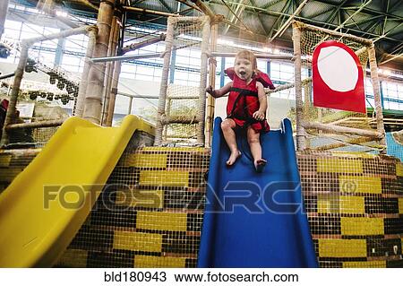 Stock Image - Caucasian girl riding slide at water park. Fotosearch