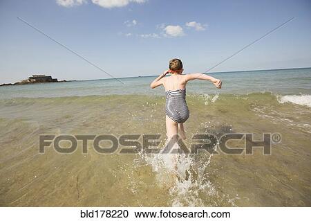 Caucasian girl splashing in waves on beach View Large Photo Image Stock Image - Caucasian girl splashing in waves on beach. Fotosearch