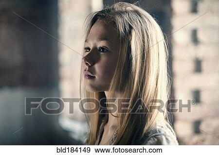 Stock Photo - Caucasian girl standing at window. Fotosearch