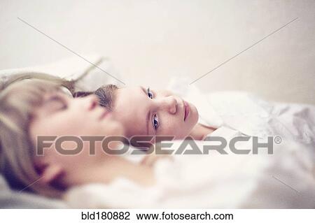 Caucasian girls laying on bed View Large Photo Image Stock Image - Caucasian girls laying on bed. Fotosearch