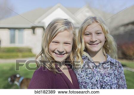 Caucasian girls smiling in yard View Large Photo Image Stock Photo - Caucasian girls smiling in yard. Fotosearch